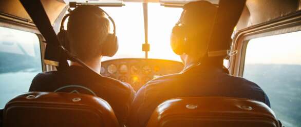 two men piloting plane during daytime